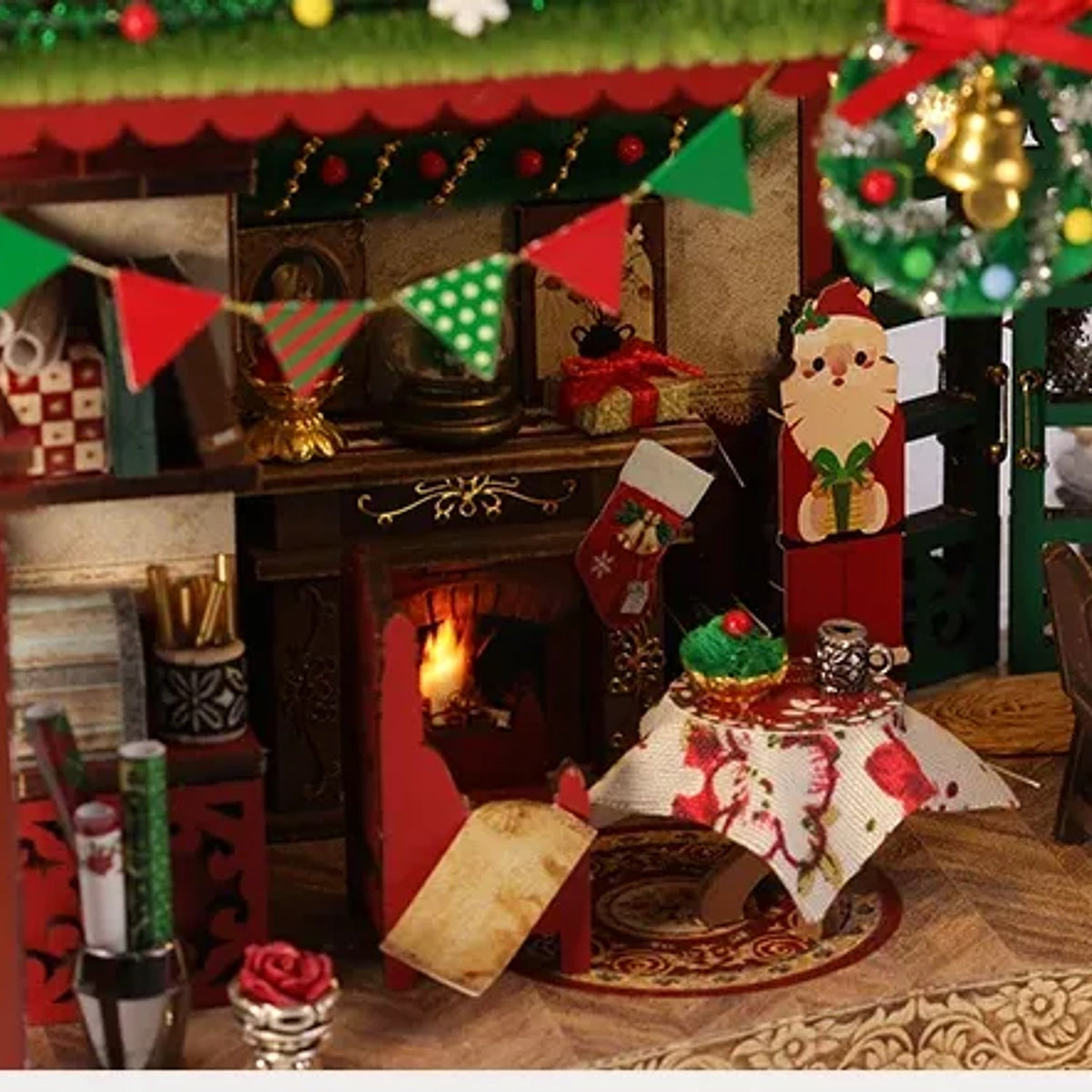 Miniature fireplace inside the Christmas lodge with stockings bunting and a tiny set table