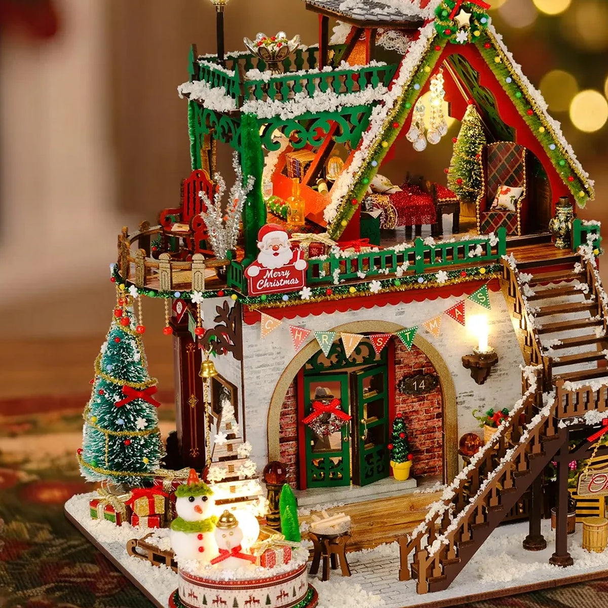 Close view of the lit Christmas lodge with its wooden stairs garlanded balcony and snowman