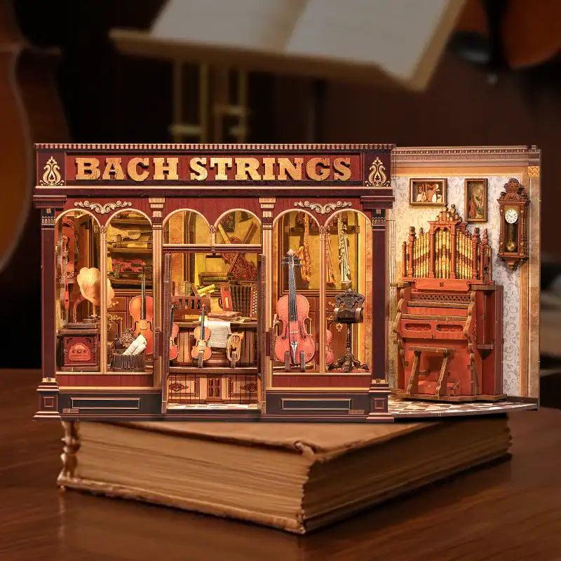 Bach Strings miniature violin workshop standing on a stack of books