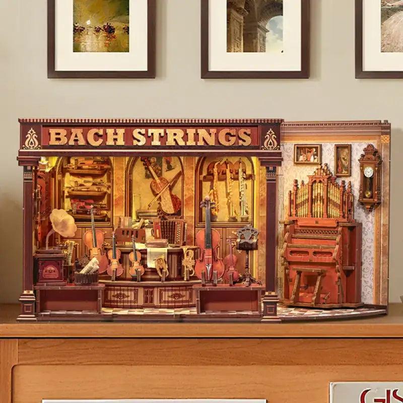 Bach Strings book nook on a shelf under framed pictures