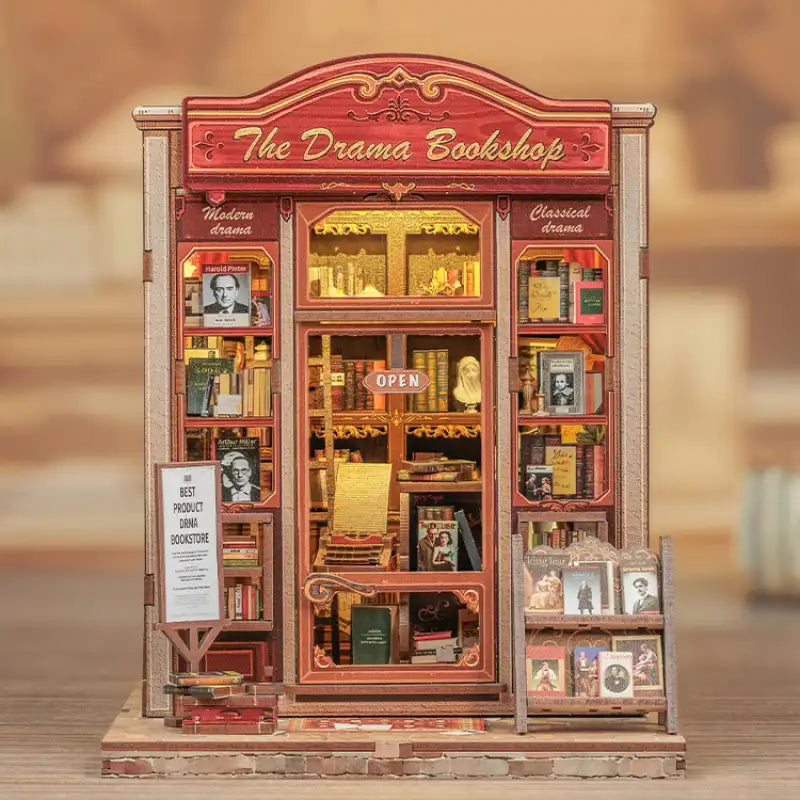 Drama Bookshop DIY book nook kit. Miniature wooden theatrical bookstore diorama with curtains, vintage books, theater posters, and warm LED lighting. Designed to slide between books on a bookshelf.