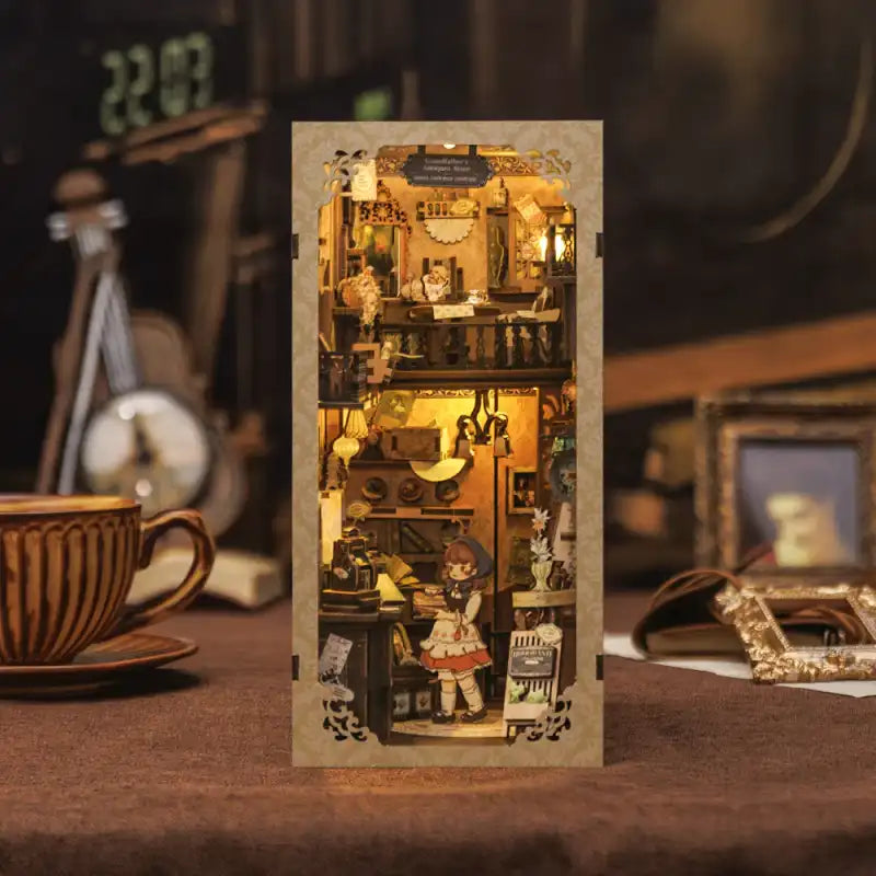 Grandfather's Antique Store DIY book nook kit. Miniature wooden antique shop diorama with vintage clocks, treasures, books, and warm LED lighting. Designed to slide between books on a bookshelf.