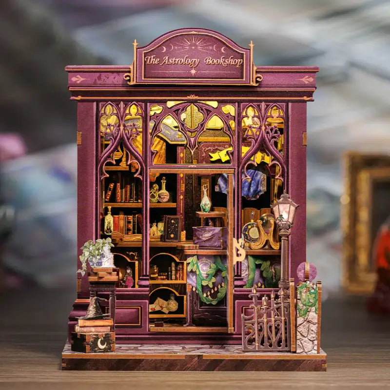 The Astrology Bookshop DIY book nook kit. Miniature wooden esoteric library diorama with ancient grimoires, celestial maps, telescopes, mystical symbols, and warm LED lighting. Designed to slide between books on a bookshelf.