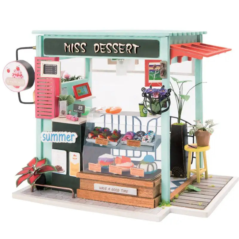Miss Dessert Shop DIY miniature house kit. Wooden model of a charming pastry shop with cakes display, pink decor, vintage details, and warm LED lighting.