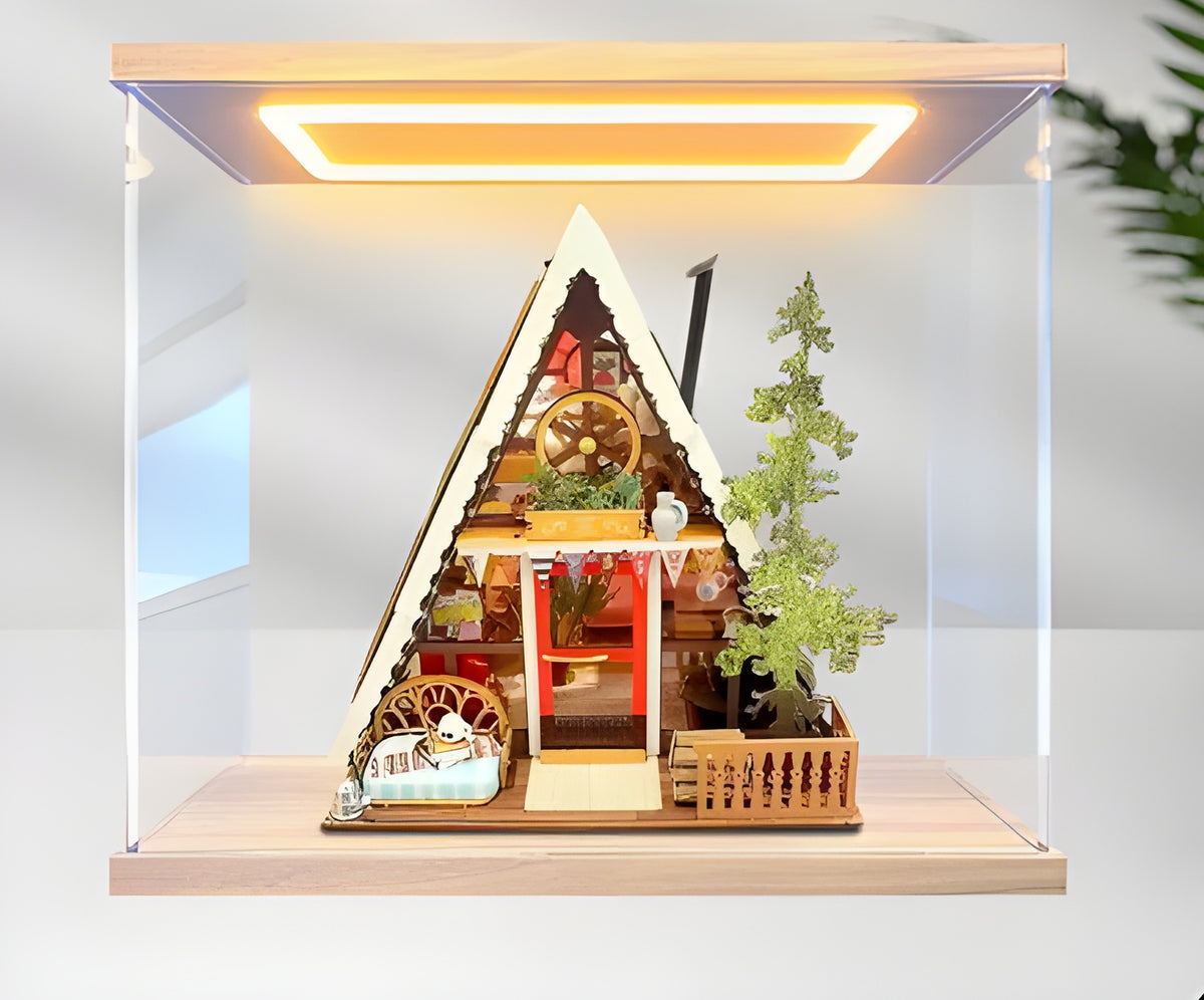 Miniature house display case with LED light in the lid, clear acrylic case on a light wood base