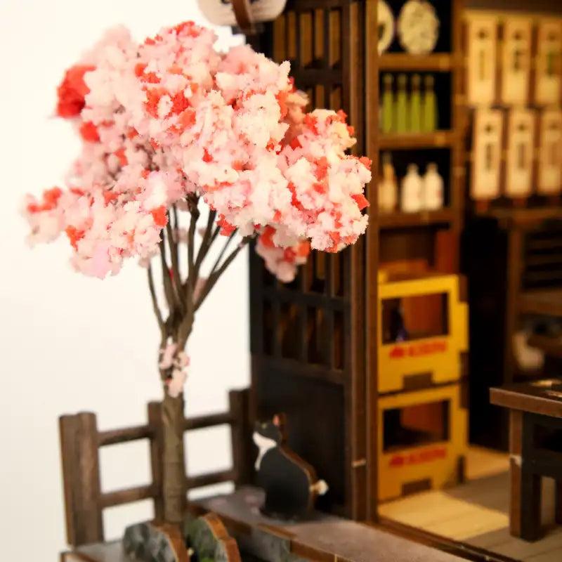 Cherry tree and black cat at the shop entrance