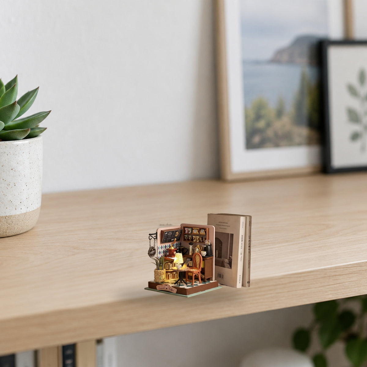 Transit Coffee miniature kit on a light wood shelf beside a plant